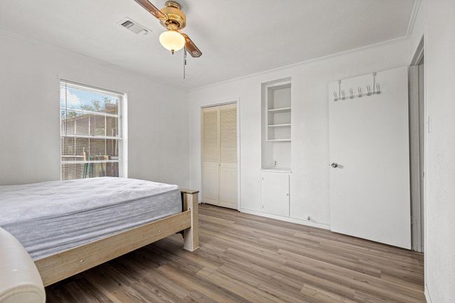 Bedroom with wood finished floors, crown molding, ceiling fan, and a closet | Image 28