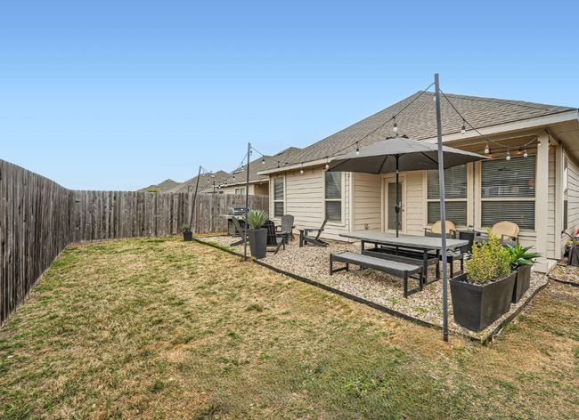 Rear view of house with a yard, a fenced backyard, and a patio area | Image 25