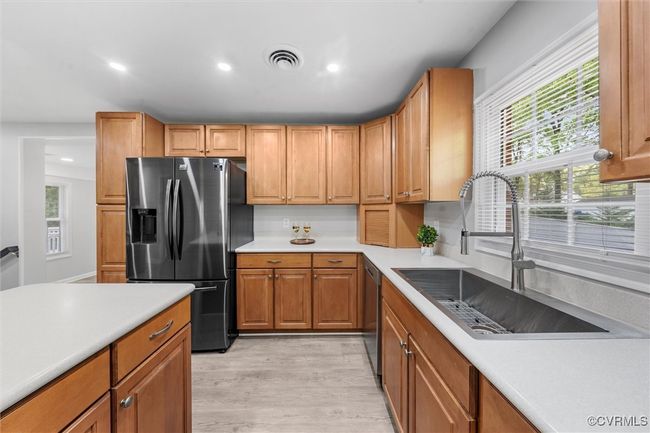 Kitchen featuring a healthy amount of sunlight, appliances with stainless steel finishes, light countertops, and a sink | Image 12