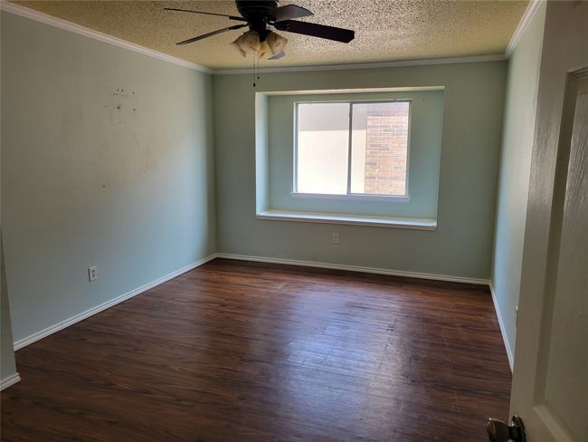 Unfurnished room featuring ornamental molding, a textured ceiling, dark wood-style flooring, and ceiling fan | Image 19