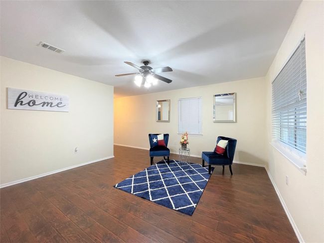 Sitting room with wood finished floors and ceiling fan | Image 5