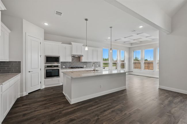 Kitchen featuring oven, gas stovetop, dark wood finished floors, a sink, and built in microwave | Image 7