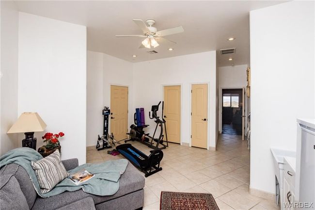 Exercise room featuring light tile patterned floors, a ceiling fan, and recessed lighting | Image 68