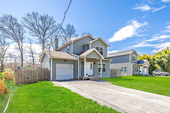 Traditional-style home featuring a chimney, an attached garage, driveway, and fence | Image 26