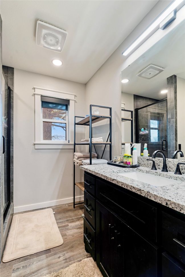 Bathroom featuring vanity, baseboards, a shower stall, visible vents, and wood finished floors | Image 16