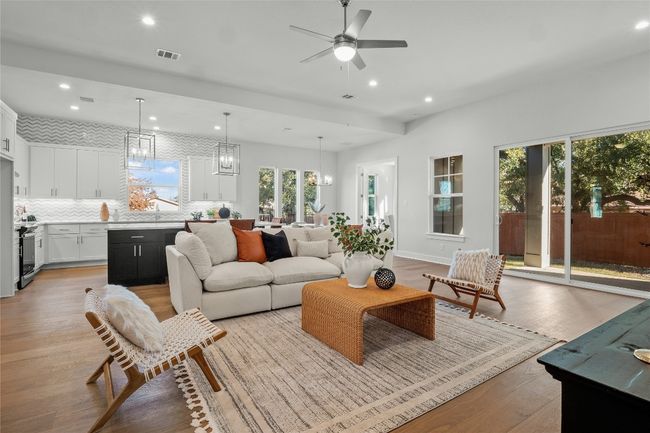 Living room with recessed lighting, light wood finished floors, visible vents, baseboards, and ceiling fan with notable chandelier | Image 6