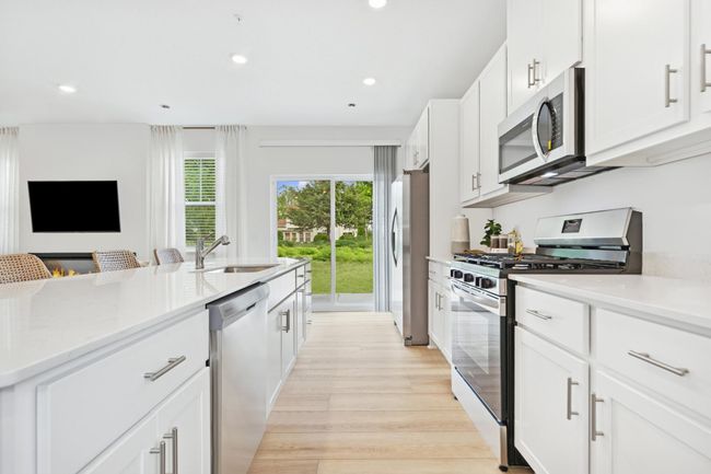 (Photo of model home, features will vary) A subway tile backsplash atop the 5-burner gas cooktop with an overhead microwave meets style with functionality | Image 4
