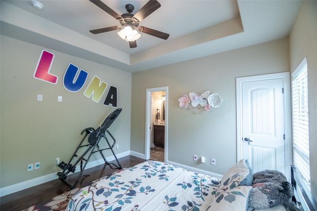Bedroom featuring baseboards, connected bathroom, and a ceiling fan | Image 27