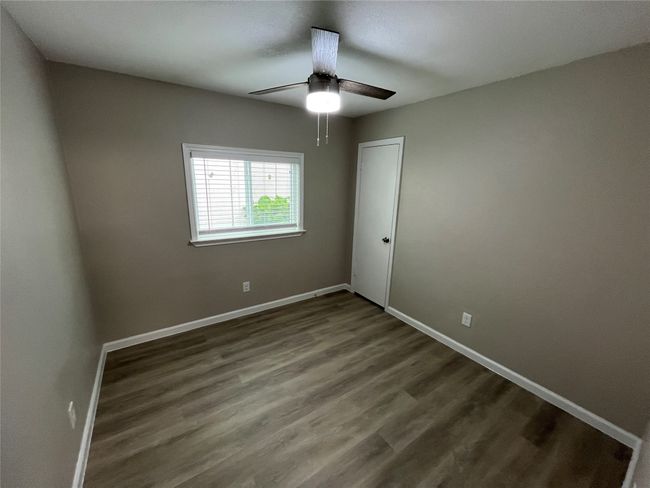 Empty room with ceiling fan, baseboards, and wood finished floors | Image 12