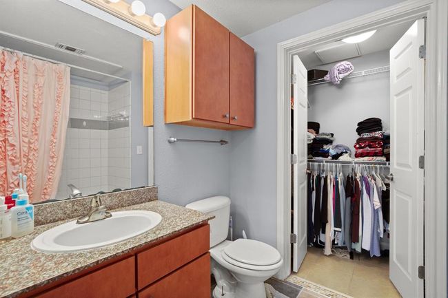 Full bath with a spacious closet, vanity, curtained shower, and tile patterned flooring | Image 17
