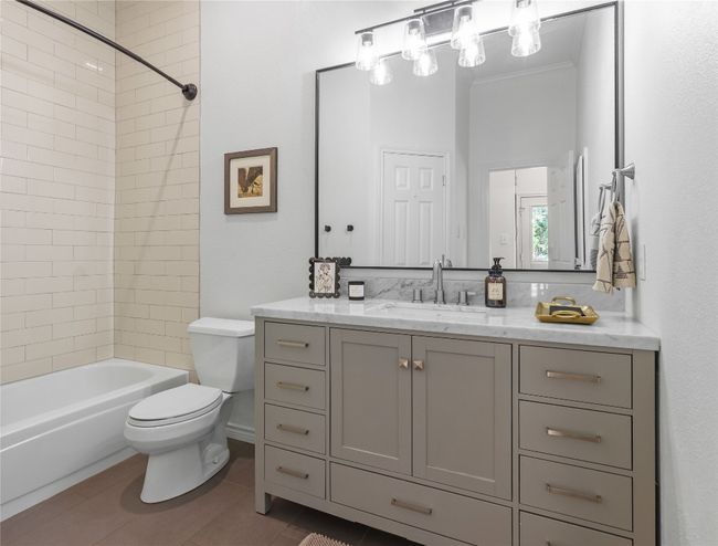 Full bathroom with shower / bathtub combination, toilet, vanity, and tile patterned floors | Image 22