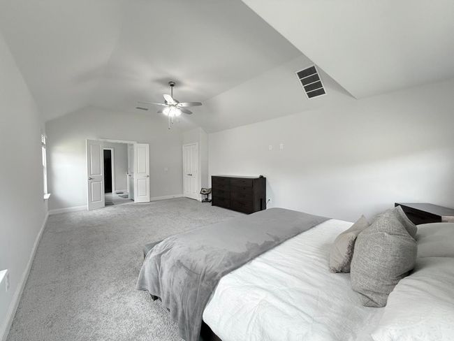 Carpeted bedroom featuring vaulted ceiling and ceiling fan | Image 13