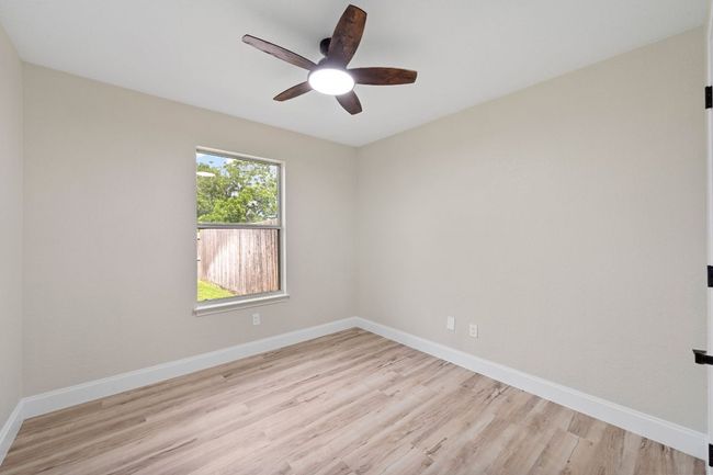 Empty room with ceiling fan and light wood-style floors | Image 19