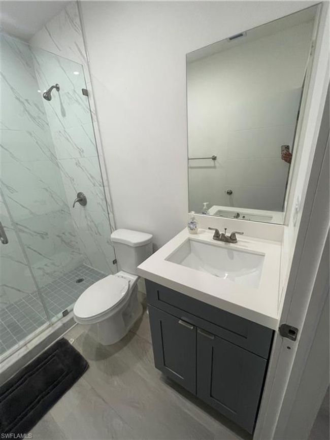 Bathroom featuring walk in shower, vanity, and toilet | Image 15