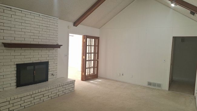 Unfurnished living room featuring carpet flooring and a fireplace | Image 4