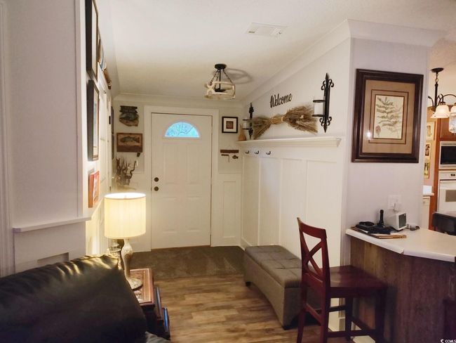 Entryway featuring wood finished floors, a decorative wall, and wainscoting | Image 4