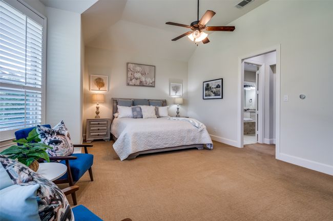 Bedroom with multiple windows, carpet floors, vaulted ceiling, ensuite bath, and a ceiling fan | Image 20