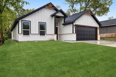 Modern inspired farmhouse with a garage and a front lawn | Image 2