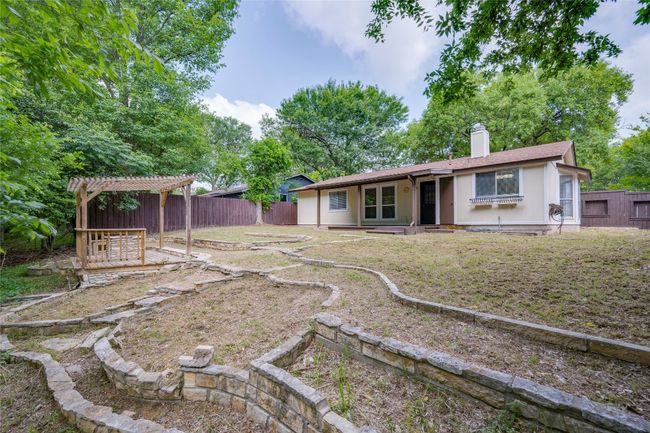 Back of house featuring a chimney, a pergola, and a fenced backyard | Image 29