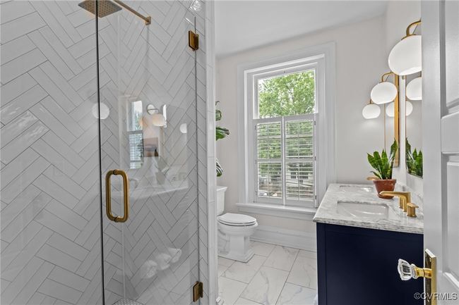 Full bathroom featuring a shower stall, toilet, a sink, and double vanity | Image 21