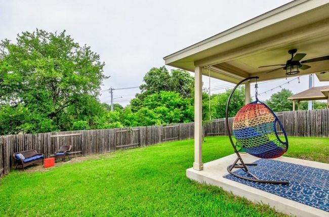 Fenced backyard with a ceiling fan and a patio | Image 18