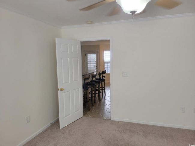 Empty room featuring crown molding, a ceiling fan, light carpet, and light tile patterned floors | Image 22