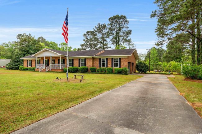 View of front of house with a front lawn, covered porch, brick siding, and concrete driveway | Image 25