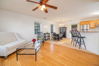 Living room with ceiling fan with notable chandelier and light hardwood / wood-style flooring | Image 2