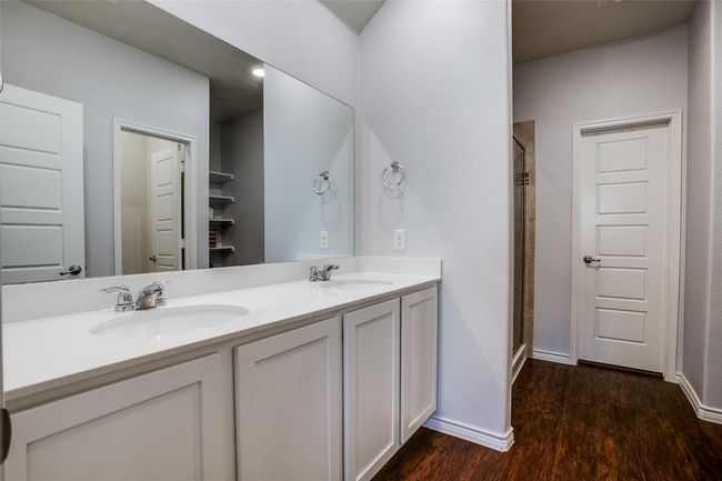 Bathroom featuring double vanity, an enclosed shower, and hardwood / wood-style flooring | Image 15