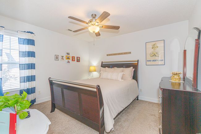 Bedroom featuring light colored carpet and ceiling fan | Image 20