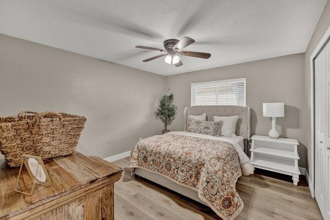 Bedroom featuring a closet, a ceiling fan, light wood finished floors, a textured ceiling, and baseboards | Image 17