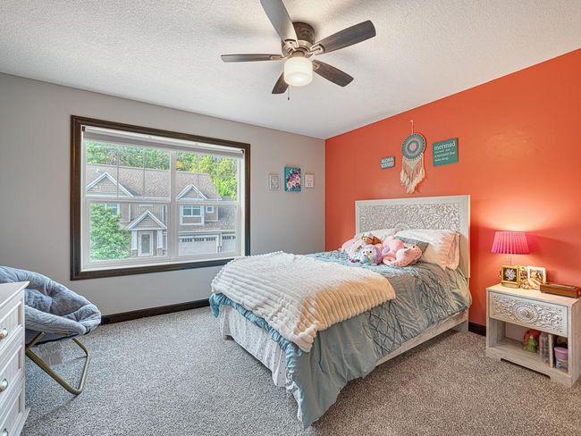 The second bedroom on the upper level is large and looks out over the street. All the bedrooms feature large closets and tons of natural light! | Image 23