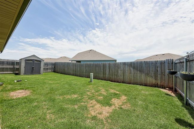 Fenced backyard with a storage shed | Image 39