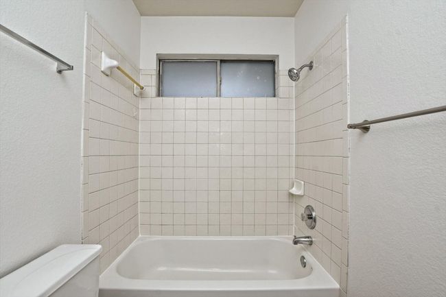 Bathroom featuring a textured wall and shower / tub combination | Image 18