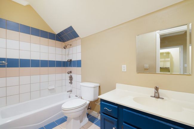 Full bath with vaulted ceiling, vanity, bathtub / shower combination, toilet, and tile patterned flooring | Image 31