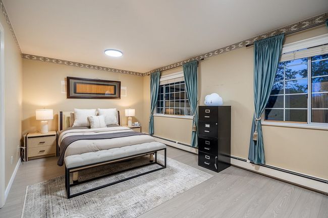 Bedroom featuring light wood-style flooring, baseboards, and a baseboard radiator | Image 22
