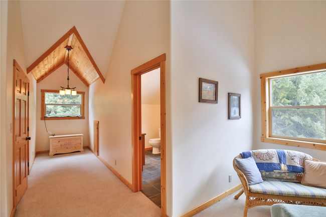Hallway featuring baseboards, light colored carpet, and high vaulted ceiling off upstairs suite | Image 34
