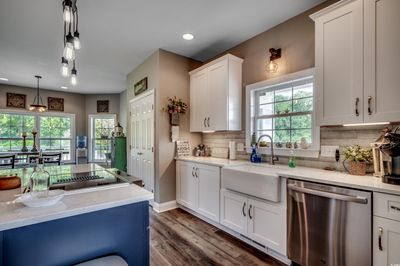 Kitchen featuring a healthy amount of sunlight, light stone counters, stainless steel dishwasher, and sink | Image 3