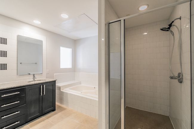 Separate glass-enclosed shower offers sleek tile, a built-in ledge, and modern chrome fixtures—great for quick mornings or post-gym refreshes. | Image 14