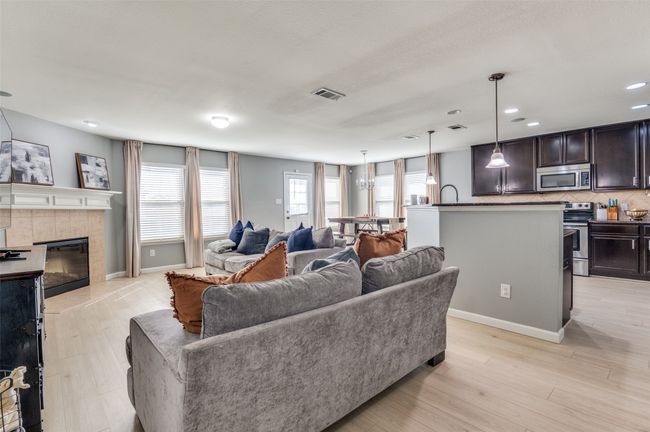 Living area with a tile fireplace, light wood-style floors, and recessed lighting | Image 20