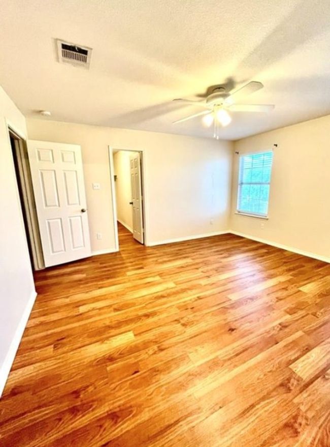 Unfurnished bedroom with light wood-type flooring, baseboards, a textured ceiling, and ceiling fan | Image 8