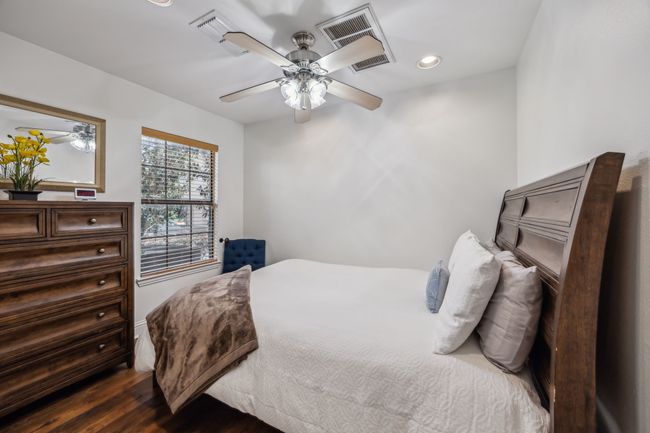 Private first-floor bedroom features hardwood floors, ample natural light, and an ensuite bath. | Image 4