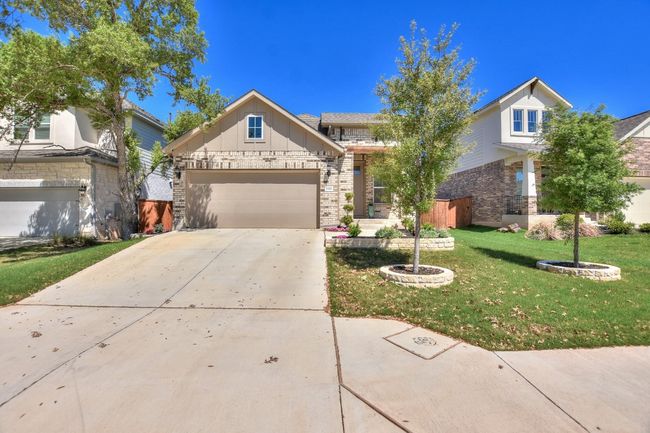 View of front of home with a front yard, an attached garage, board and batten siding, and concrete driveway | Image 27