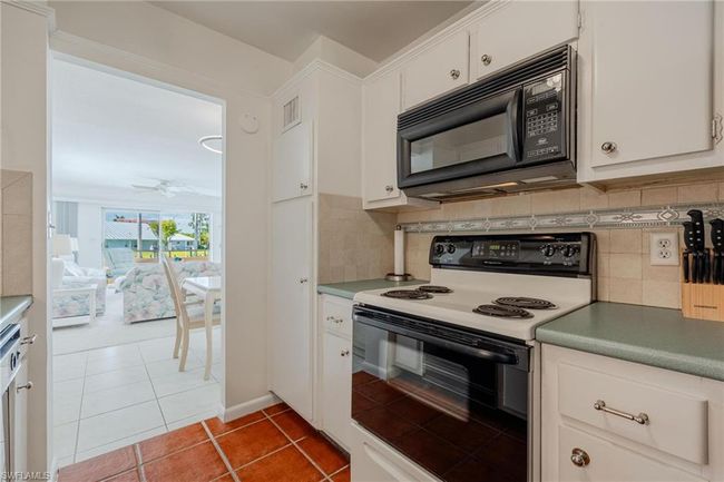 Kitchen featuring backsplash, white cabinetry, ceiling fan, and white electric range | Image 16