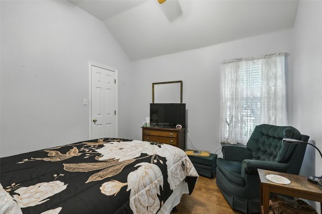 Bedroom with wood finished floors and lofted ceiling | Image 24