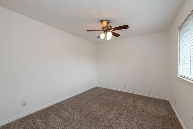 Spare room featuring dark carpet, baseboards, and a ceiling fan | Image 17
