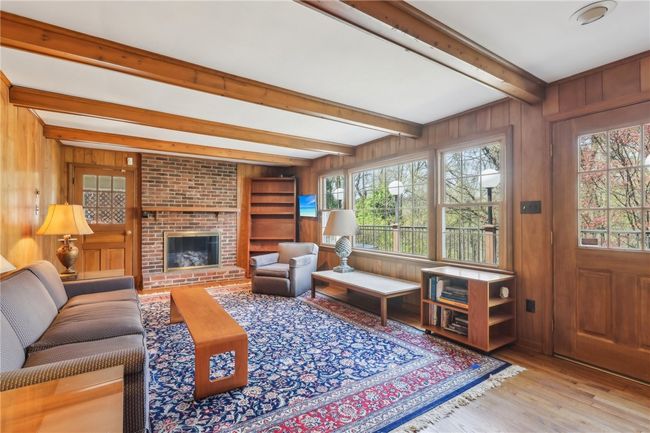 Gas log fireplace and wall of windows overlooking deck and private backyard. | Image 13