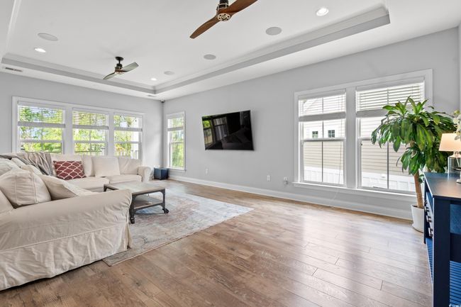 Living area with ceiling fan, a raised ceiling, hardwood / wood-style flooring, and recessed lighting | Image 6