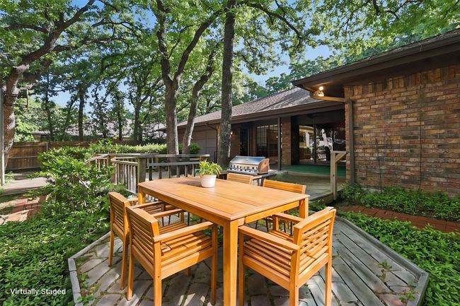 Virtually Staged Wooden deck featuring outdoor dining space, a grill, and fence | Image 36