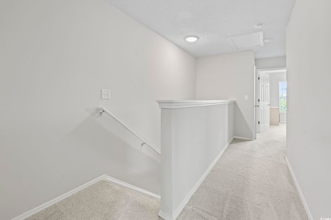 Hall featuring an upstairs landing, carpet flooring, and attic access | Image 12